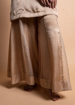 Load image into Gallery viewer, Tashi - Beige-Gold Sharara Suit Set with a Satin Top, Adorned with Handcrafted Ari-Zardozi Embroidery and Striped Chanderi Facing, Paired with Satin Bottoms and a Delicate Tissue Chanderi Dupatta
