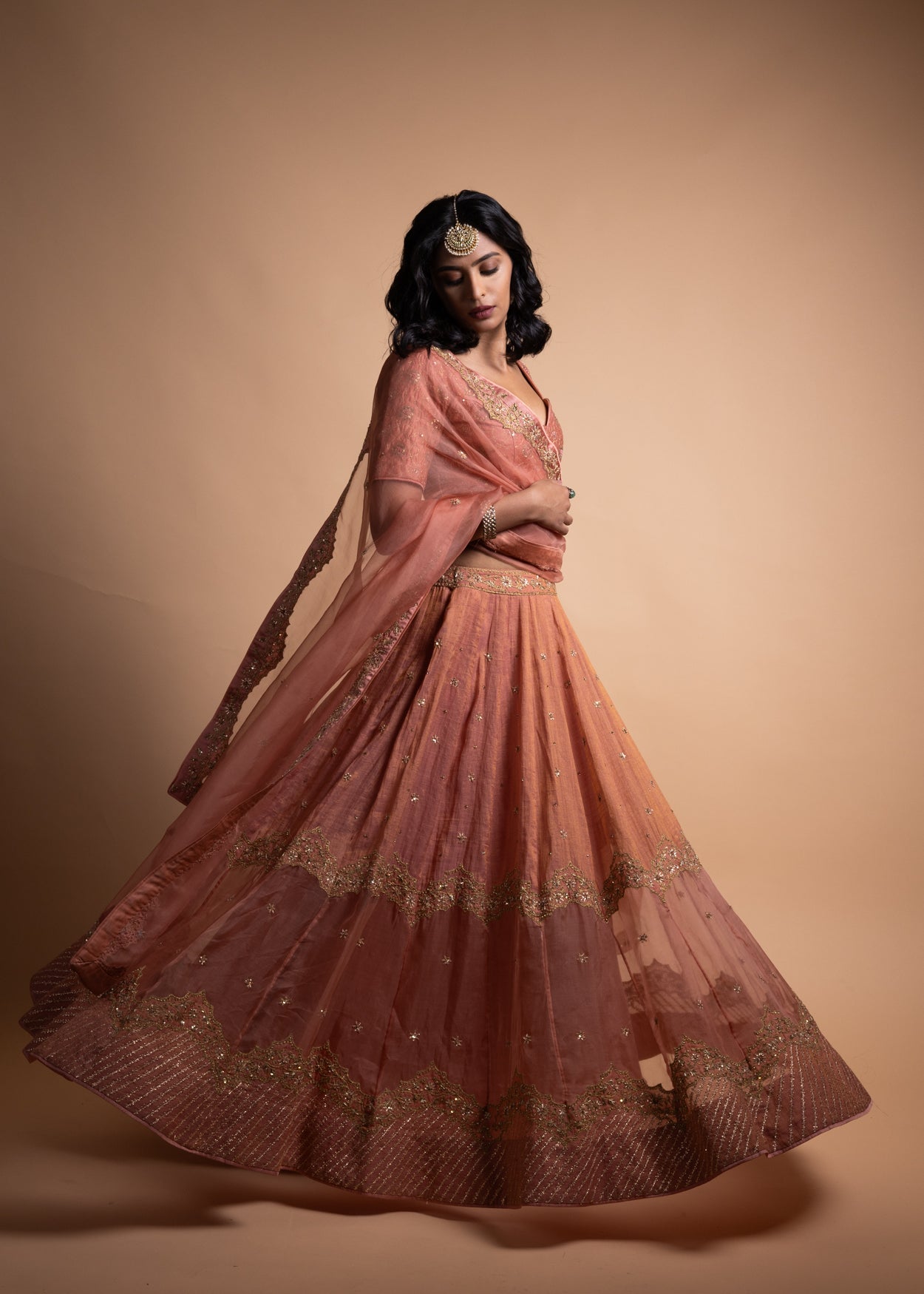Tira- Peach Chanderi Silk Blouse and Tonal Tissue Chanderi Lehenga with Organza Silk Panels Paired with Banarasi Silk Tissue Dupatta in Handcrafted in Ari-Zardozi Embroidery and Gota Appliques