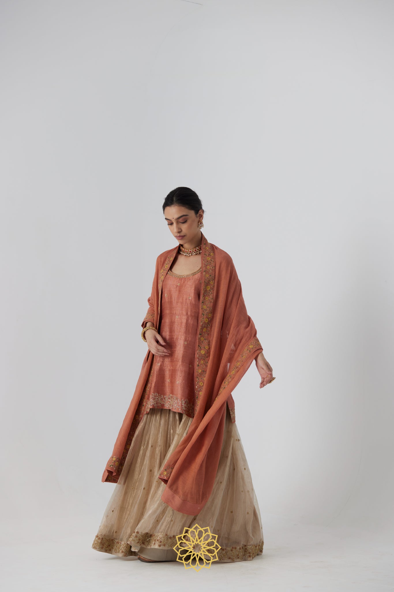 Tanira- A rust peach hand embroidered raw silk kurta with soft gold banarasi silk tissue sharara
