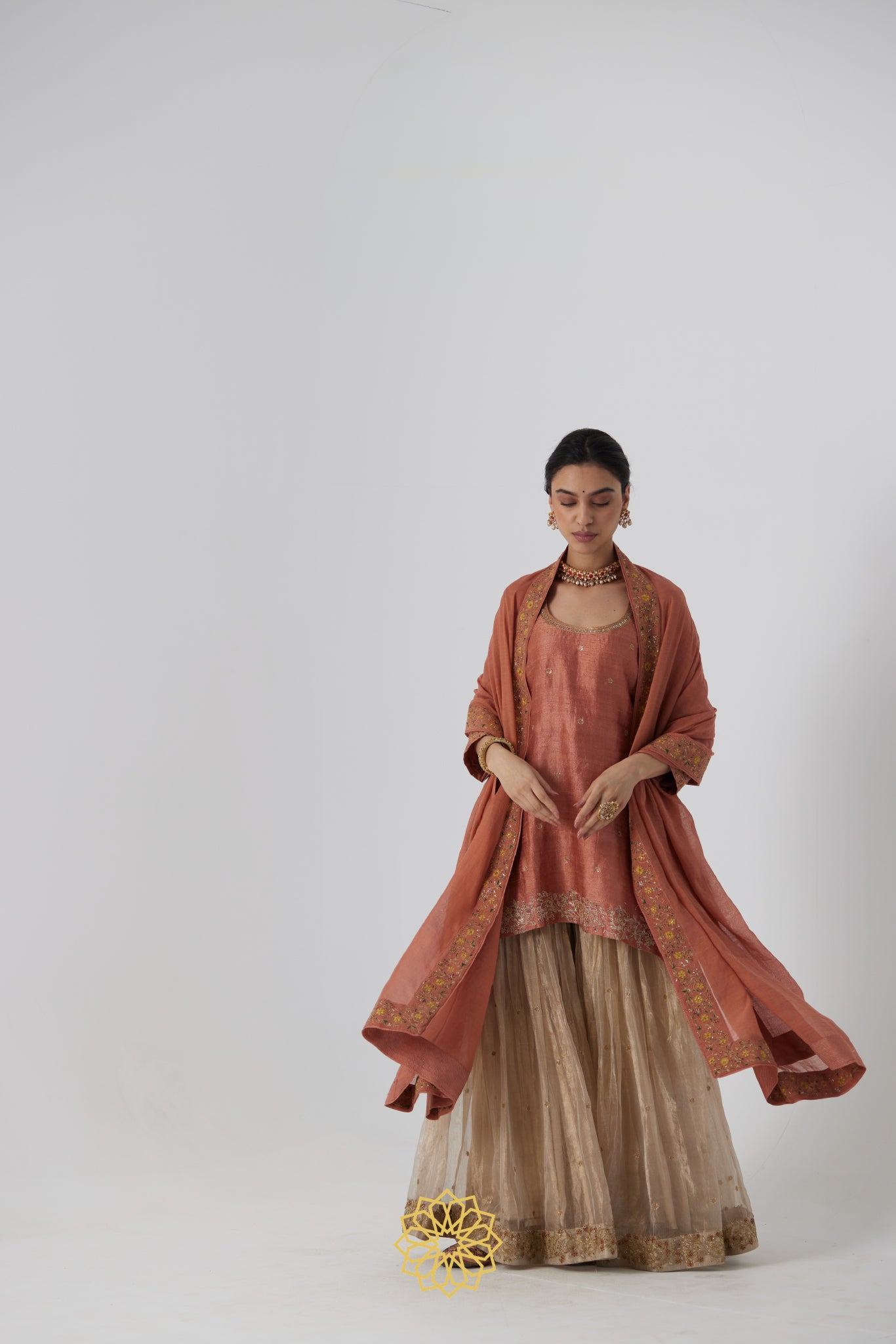 Tanira- A rust peach hand embroidered raw silk kurta with soft gold banarasi silk tissue sharara