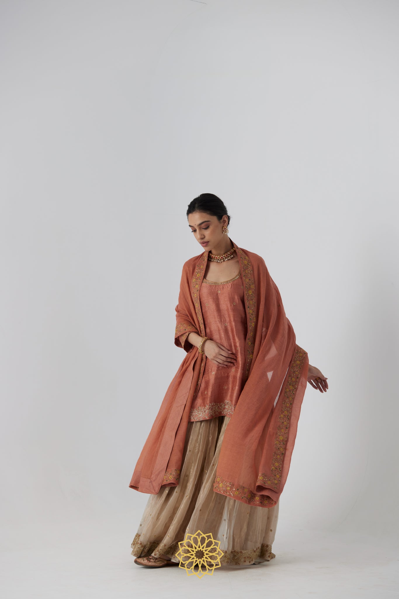 Tanira- A rust peach hand embroidered raw silk kurta with soft gold banarasi silk tissue sharara